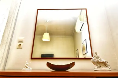 a mirror on a wall above a wooden table at Athens Authentic Elegance at Acropolis in Athens