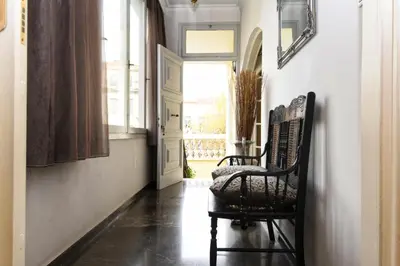a hallway with a chair and a window at Athens Authentic Elegance at Acropolis in Athens
