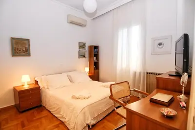 a bedroom with a bed and a desk and a television at Athens Authentic Elegance at Acropolis in Athens