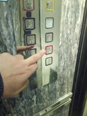 a person pressing a button on an elevator at New studio next to metro for 2 people in Athens