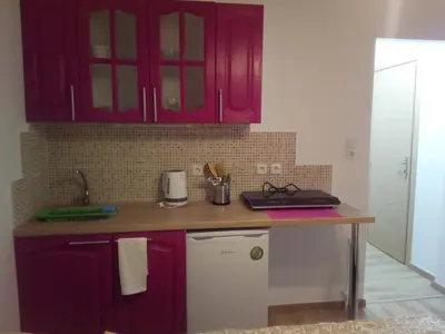 a kitchen with red cabinets and a counter top at New studio next to metro for 2 people in Athens