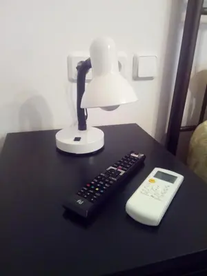 a lamp and a remote control sitting on a table at New studio next to metro for 2 people in Athens