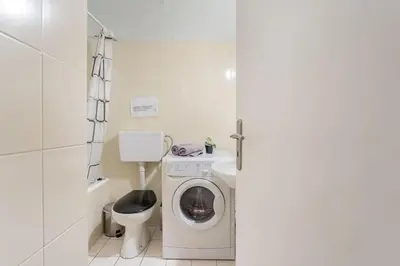 a small bathroom with a washing machine and a toilet at 2BDR OlympianZeus Apt with Netflix in Athens