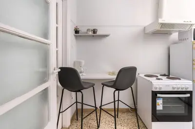 a small kitchen with two chairs and a table and a stove at 2BDR OlympianZeus Apt with Netflix in Athens