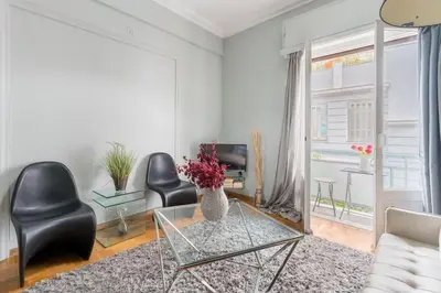 a living room with a glass table and black chairs at 2BDR OlympianZeus Apt with Netflix in Athens