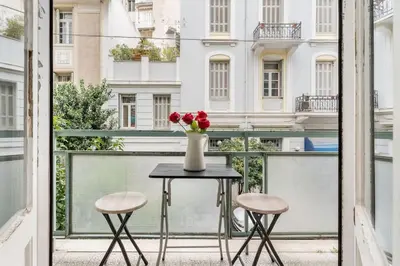 a table with a vase of flowers on a balcony at 2BDR OlympianZeus Apt with Netflix in Athens