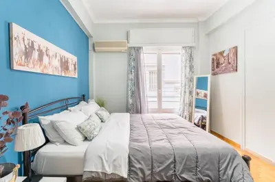 a bedroom with a bed with a blue wall at 2BDR OlympianZeus Apt with Netflix in Athens