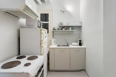 a white kitchen with a stove and a refrigerator at 2BDR OlympianZeus Apt with Netflix in Athens