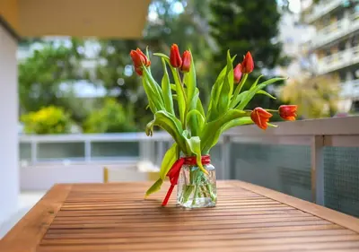 a vase filled with red tulips sitting on a table at Athena's Comet in Athens