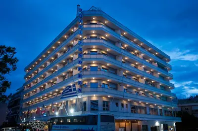 a tall white building with lights on it at Xenophon Hotel in Athens