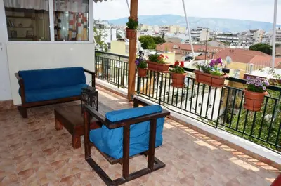 a balcony with a blue chair and a table at Helen house in Athens