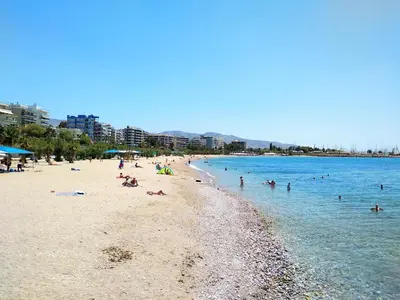 a group of people swimming in the water on a beach at Helen house in Athens