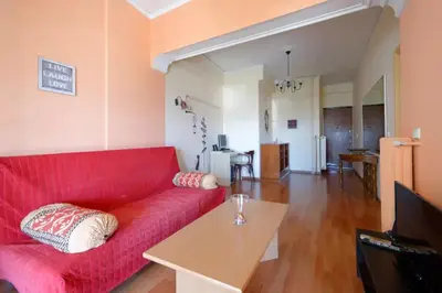 a living room with a red couch and a table at Helen house in Athens