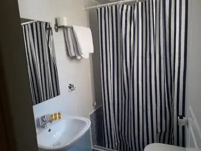 a bathroom with a black and white shower curtain and a sink at Filon in Piraeus