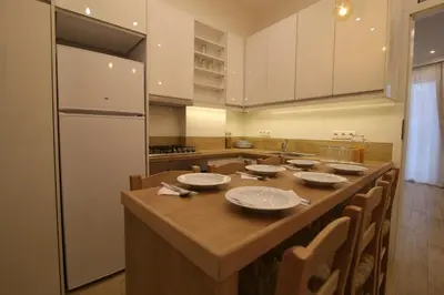 a kitchen with a long table with chairs and a refrigerator at Luxurious Athenian Apartment in Athens