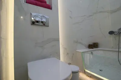 a white bathroom with a toilet and a tub at Luxurious Athenian Apartment in Athens