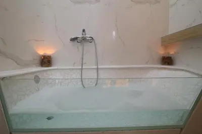 a bath tub with a shower in a bathroom at Luxurious Athenian Apartment in Athens