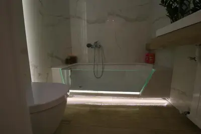 a bathroom with a bathtub with a light in it at Luxurious Athenian Apartment in Athens