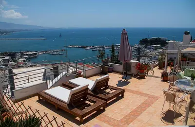 a balcony with two lounge chairs and an umbrella at Piraeus Lux Secret in Piraeus