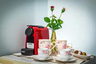 a table with three coffee cups and a toaster at Piraeus Lux Secret in Piraeus