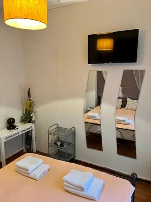 a room with a table with two beds and a mirror at Central flat - 2 Metro stops from ACROPOLIS-PLKA in Athens