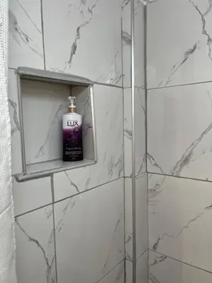 a bathroom with a bottle of liquid soap on a shelf at Central flat - 2 Metro stops from ACROPOLIS-PLKA in Athens