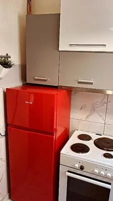 a red refrigerator next to a stove in a kitchen at Central flat - 2 Metro stops from ACROPOLIS-PLKA in Athens