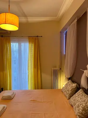 a bedroom with a large bed and a window at Central flat - 2 Metro stops from ACROPOLIS-PLKA in Athens