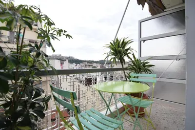 a balcony with a green table and chairs at Acropolis View Apartment in Central Athens! SQ1 in Athens