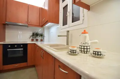 a kitchen with wooden cabinets and a counter top at Acropolis View Apartment in Central Athens! SQ1 in Athens