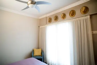 a bedroom with a ceiling fan and a window at Acron of Plaka by YHA in Athens