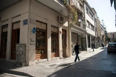 a person walking down a street in front of a building at Acron of Plaka by YHA in Athens