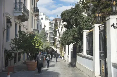 a group of people walking down a street at Acron of Plaka by YHA in Athens