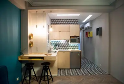 a small kitchen with two bar stools at a counter at Acron of Plaka by YHA in Athens