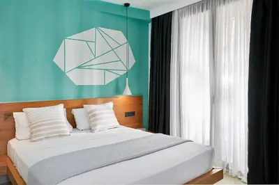 a bedroom with a large bed with a blue wall at Mosaikon in Athens