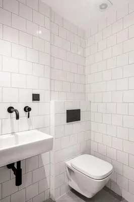 a white bathroom with a toilet and a sink at Mosaikon in Athens
