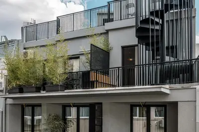 an apartment building with balconies and potted plants at Mosaikon in Athens