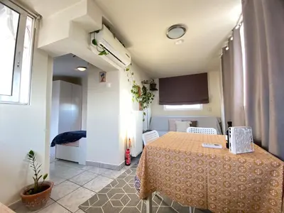 a small room with a table and a kitchen at Top Floor Apt with Balcony - Acropolis View & Sunset - Koukaki in Athens