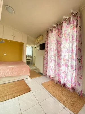 a bedroom with pink curtains and a bed with two rugs at Top Floor Apt with Balcony - Acropolis View & Sunset - Koukaki in Athens
