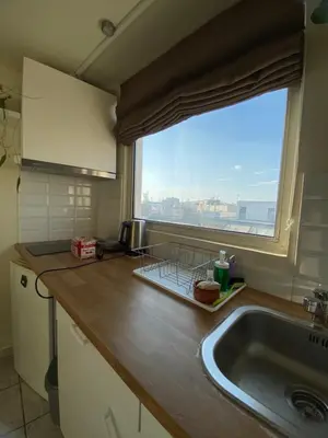 a kitchen with a sink and a large window at Top Floor Apt with Balcony - Acropolis View & Sunset - Koukaki in Athens
