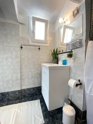 a bathroom with a white sink and a shower at Top Floor Apt with Balcony - Acropolis View & Sunset - Koukaki in Athens