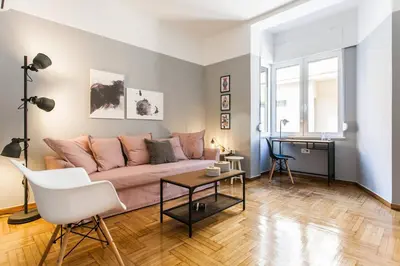 a living room with a pink couch and a table at Chic and Cosy Flat in Plaka by UPSTREET in Athens