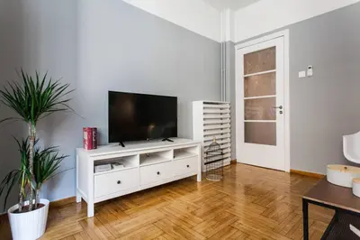 a living room with a television on a white cabinet at Chic and Cosy Flat in Plaka by UPSTREET in Athens