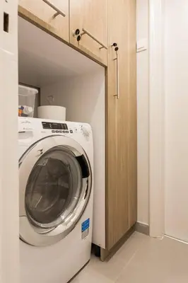 a washer and dryer in a laundry room with a cabinet at Chic and Cosy Flat in Plaka by UPSTREET in Athens