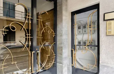a store front with gold metal decorations on the door at Chic and Cosy Flat in Plaka by UPSTREET in Athens