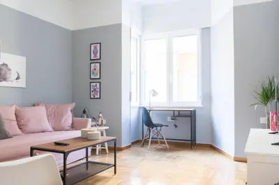 a living room with a pink couch and a table at Chic and Cosy Flat in Plaka by UPSTREET in Athens
