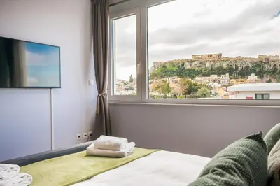 a bedroom with a window with a view ofhens at Breathtaking View Studio! in Athens