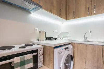a kitchen with a washer and a washing machine at Breathtaking View Studio! in Athens