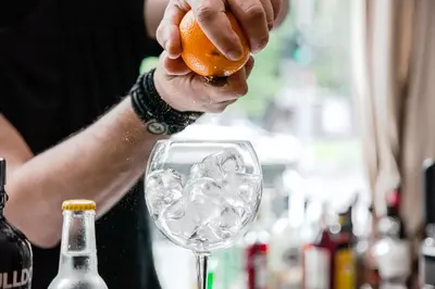a person is pouring a drink into a wine glass at B4B Athens Signature Hotel in Athens