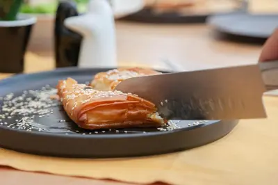 a knife sitting on top of a plate with a pastry at B4B Athens Signature Hotel in Athens